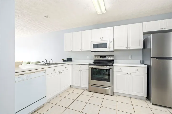 White cabinetry and tile flooring define this highly functional kitchen layout.
