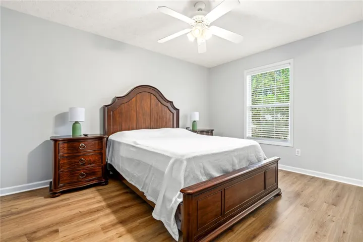 Gleaming hardwood floors and a large window set a tranquil tone in this bedroom.
