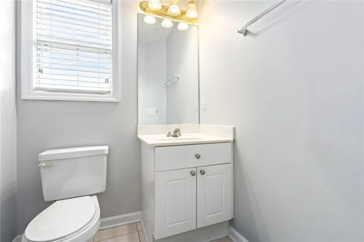 Smooth walls and tiled flooring frame a classic vanity area with integrated sink.