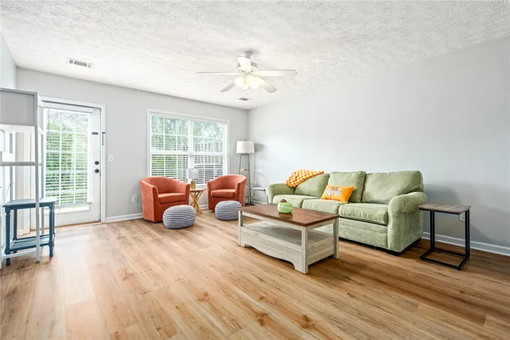Rich wood-look flooring and generous natural light create an inviting living space.