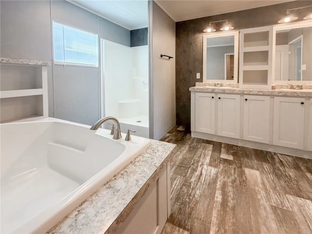 A spacious bathroom layout pairs a soaking tub with a generous double vanity.