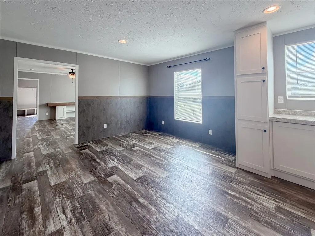 Textured flooring pairs with paneling and built-in cabinetry in this open dining area.