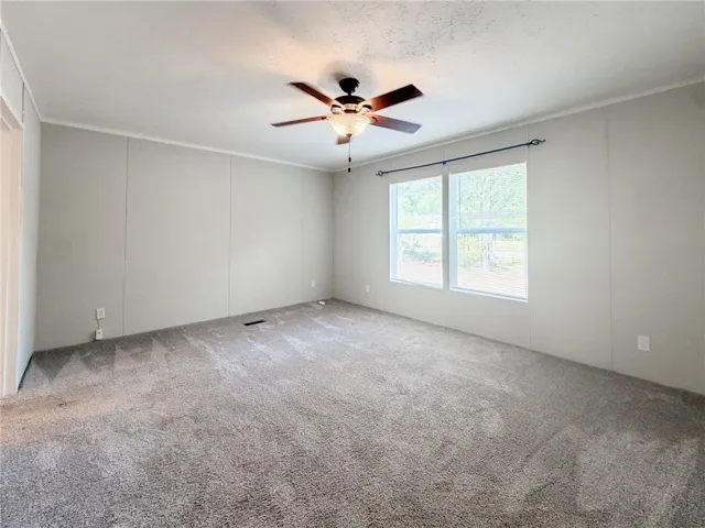 Plush wall-to-wall carpeting and twin windows define this versatile room.