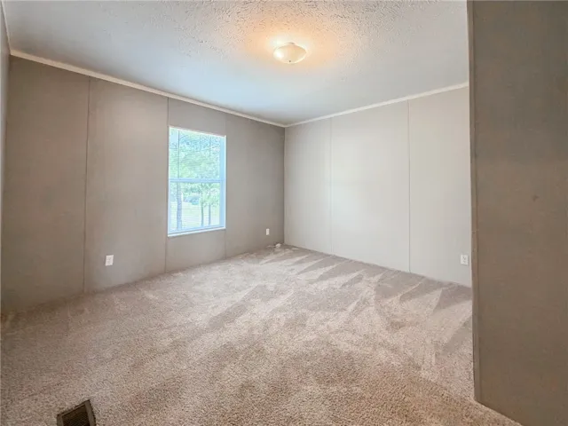 Plush wall-to-wall carpeting and a bright window define this versatile secondary bedroom space.