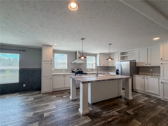 Rich wood-look flooring anchors this open kitchen workspace highlighted by a central prep island.