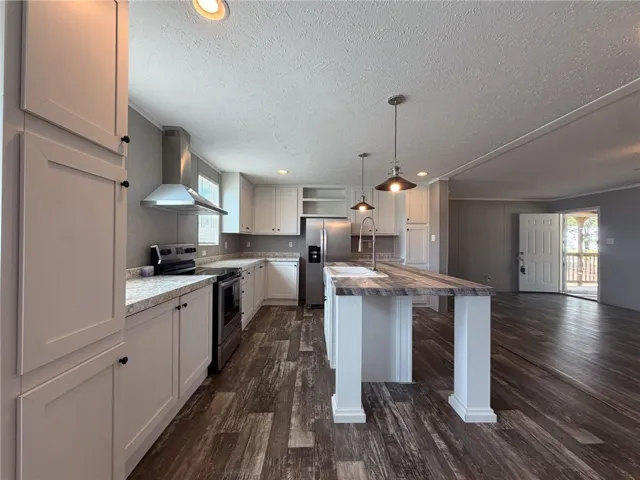 Gleaming wood-look floors anchor this updated kitchen showcasing an expansive central island and modern cabinetry.