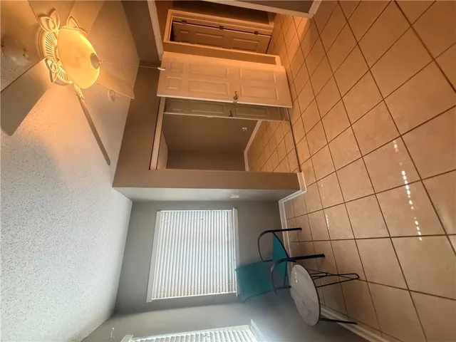 Tiled flooring and a large mirrored closet define this functional transition space.