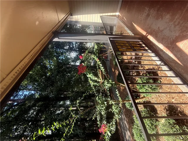 An elevated private balcony looks out over a tranquil, tree-lined landscape.
