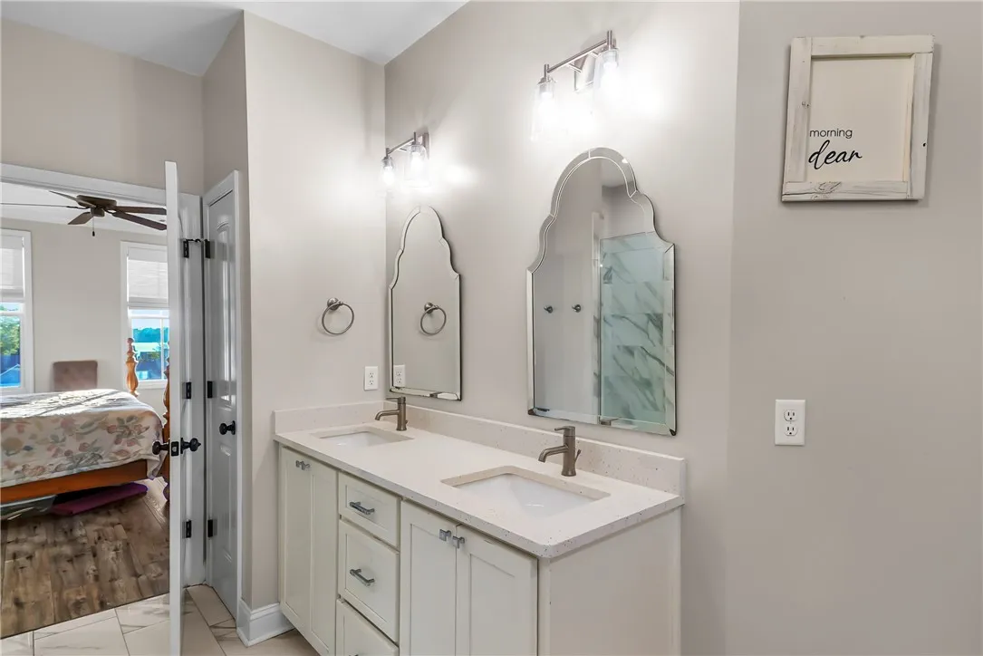 An elegant vanity with stone counters and dual sinks anchors the primary bathroom.