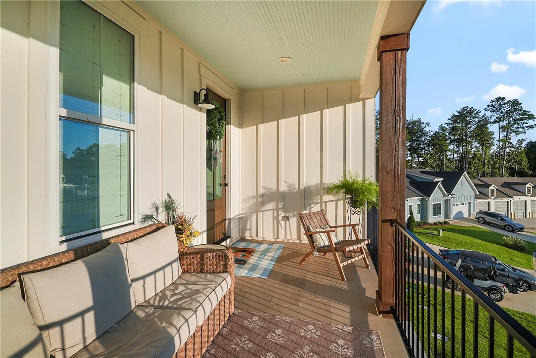 A welcoming front porch features a tongue-and-groove ceiling, board-and-batten siding, and metal railings.