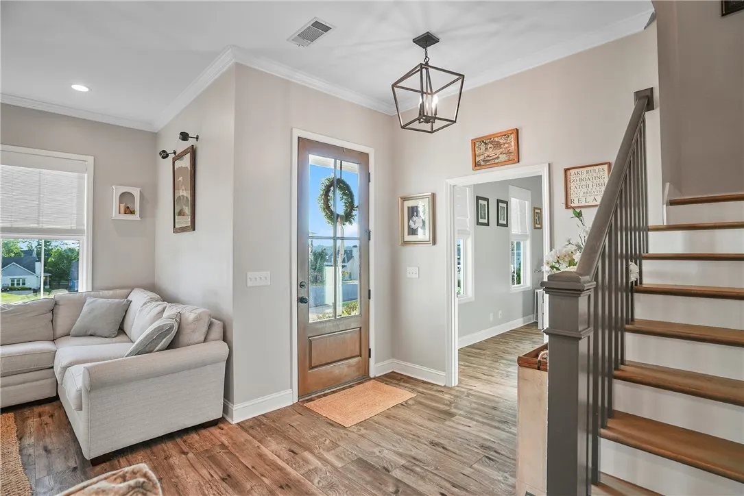 Rich wood flooring and a classic staircase anchor this welcoming home entryway.
