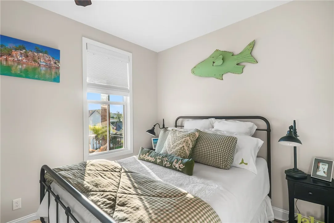 Natural light streams through a tall window in this cozy and comfortable bedroom.