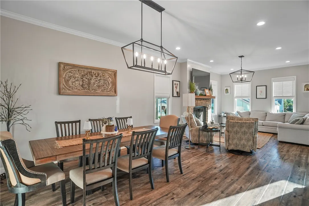 Rich wood flooring anchors this open layout connecting the dining space to the living room.