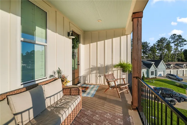 A welcoming front porch features a tongue-and-groove ceiling, board-and-batten siding, and metal railings.