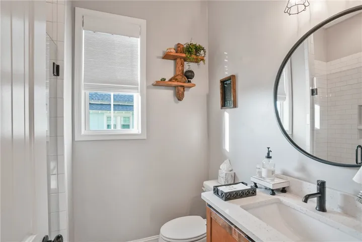 Natural light from a classic window brightens a bathroom with stone counters.