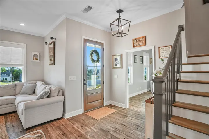 Rich wood flooring and a classic staircase anchor this welcoming home entryway.