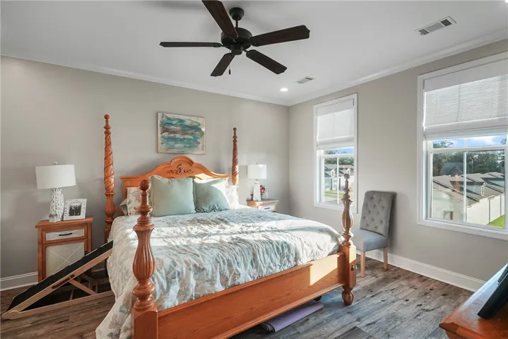 Hardwood floors and tall windows define this peaceful bedroom retreat.