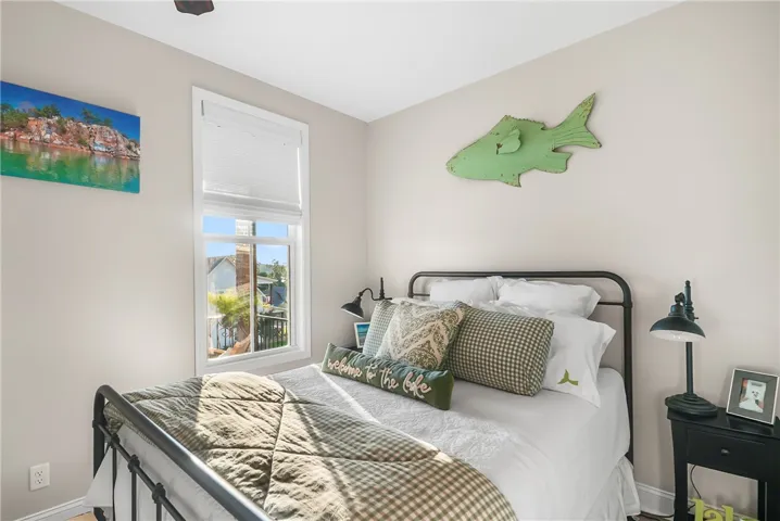 Natural light streams through a tall window in this cozy and comfortable bedroom.