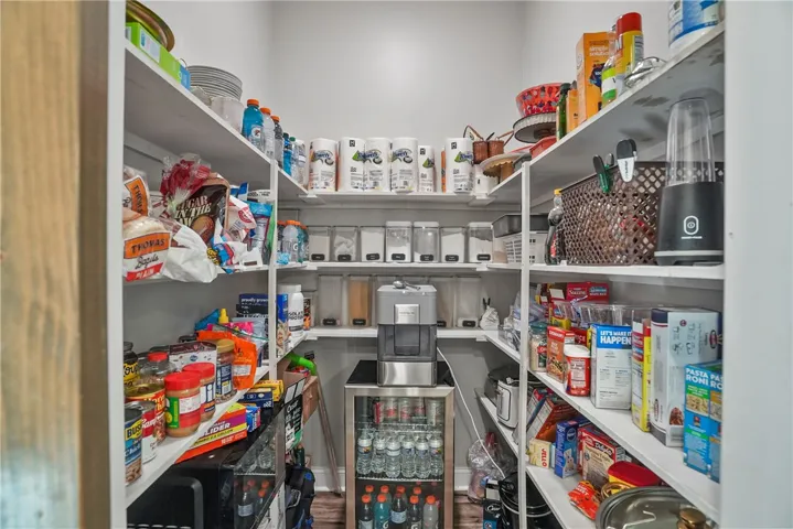 Ample built-in shelving maximizes storage potential in this highly functional walk-in pantry space.