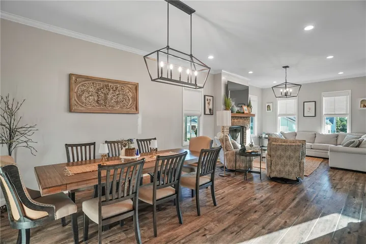 Rich wood flooring anchors this open layout connecting the dining space to the living room.