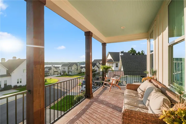 Substantial wood pillars and metal railings frame pleasant neighborhood vistas from this covered porch.