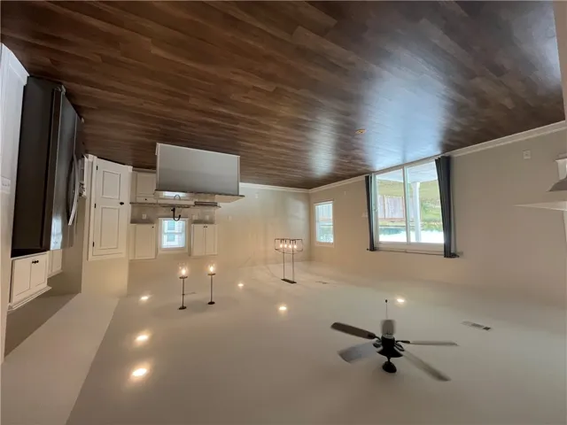 Polished hardwood floors underlay a sprawling open layout flowing seamlessly from the kitchen.