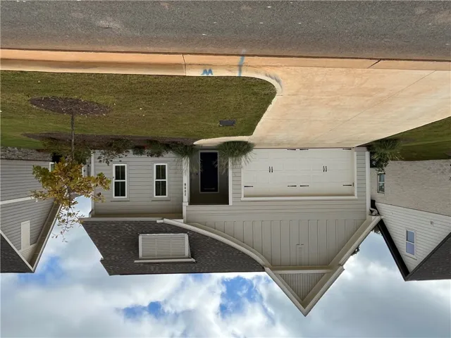 A concrete driveway leads to the spacious two-car garage of this modern craftsman home.