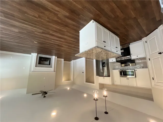 Granite countertops and crisp cabinetry anchor this seamless open kitchen and living area.