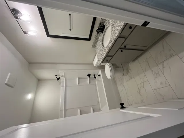 Gleaming stone counters paired with custom tile flooring elevate this pristine bathroom space.