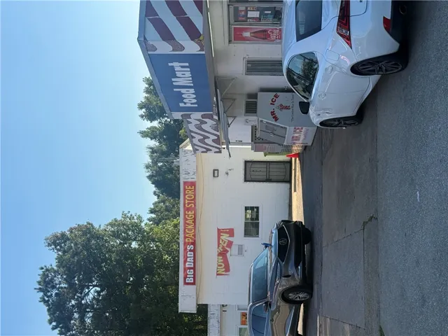 An asphalt driveway provides direct access to this established commercial storefront building.