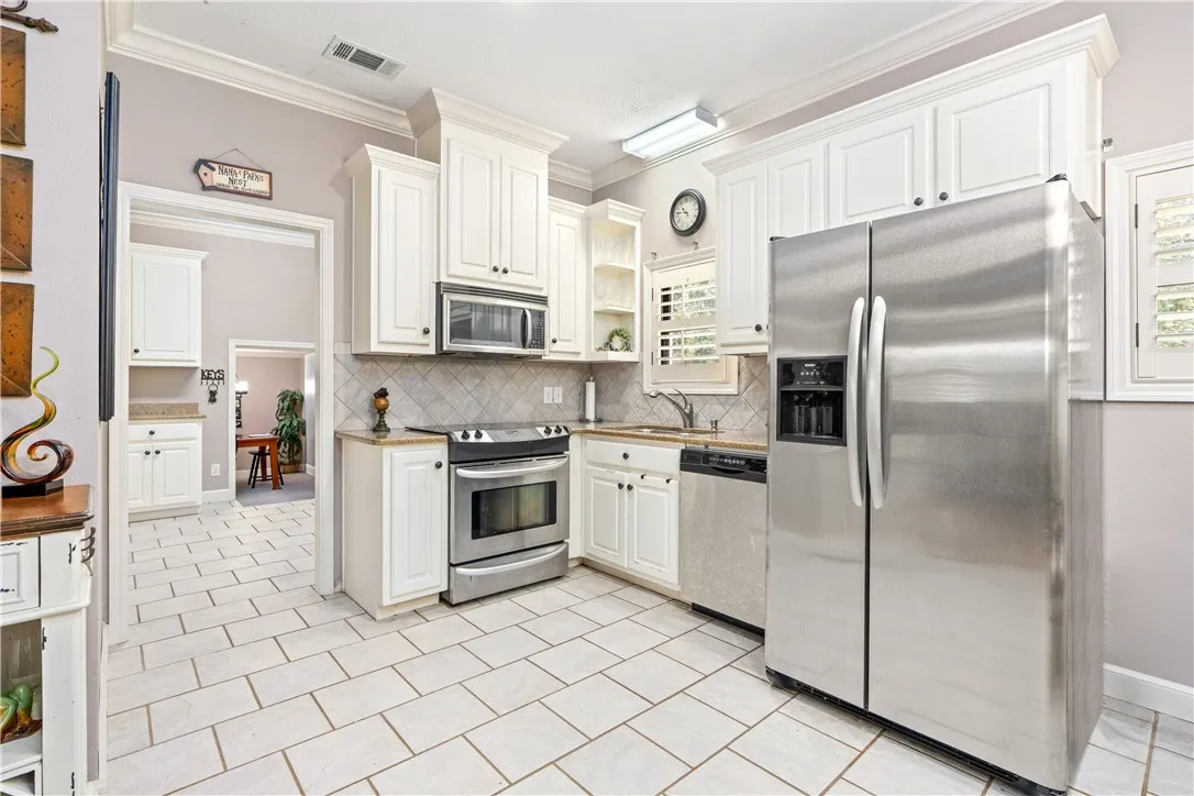White cabinetry and tile flooring define this well-appointed kitchen.