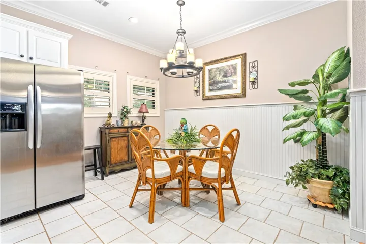 Elegant crown molding and classic wainscoting define this inviting tiled dining area.
