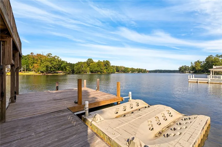 Quiet lakefront living starts on this wooden dock with personal watercraft lifts.