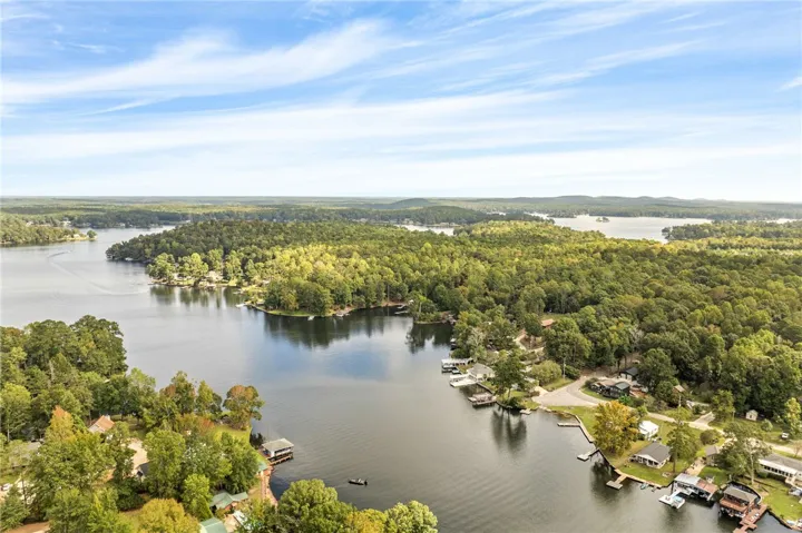 Lush forested hills surround the calm blue waters of this expansive lakeside community.