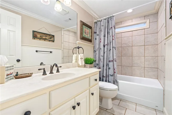 Tiled walls and a classic vanity define this comfortable bathroom space.