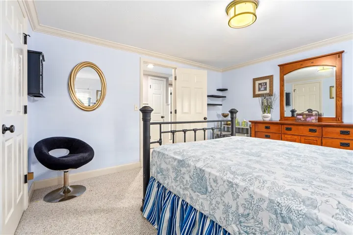 Classic crown molding and soft neutral carpeting define this restful sleeping space.