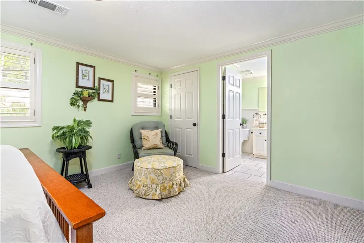 Crown molding and textured carpeting define this comfortable bedroom suite with an adjoining bath.