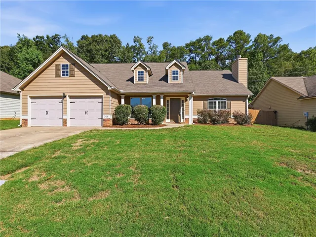 A classic facade showcasing dormer windows, cement board siding, and a spacious green lawn.