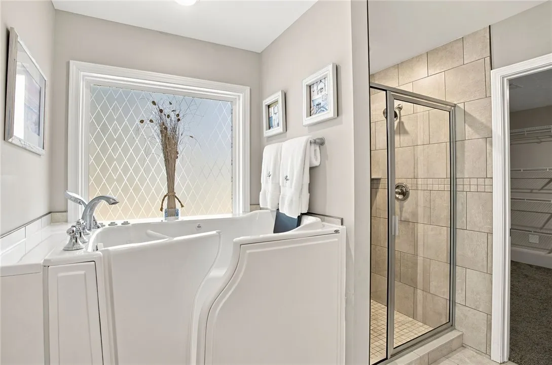Tiled walk-in shower alongside a modern jetted tub