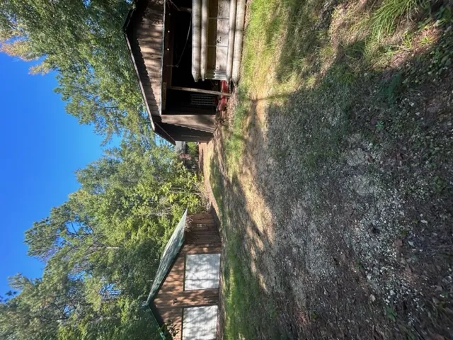Rustic wooden outbuildings provide excellent storage options nestled among mature trees.