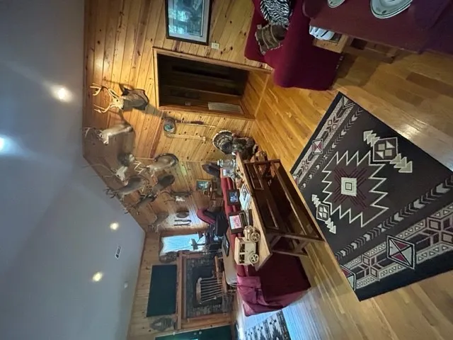 Gleaming hardwood floors and rich wood paneling create a warm, inviting rustic ambiance.