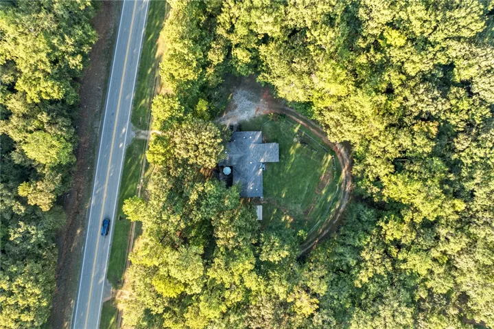 Mature woodlands envelope this secluded property, offering privacy from the nearby roadway.