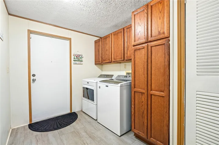 A functional laundry space features wood cabinetry alongside washer and dryer hookups.