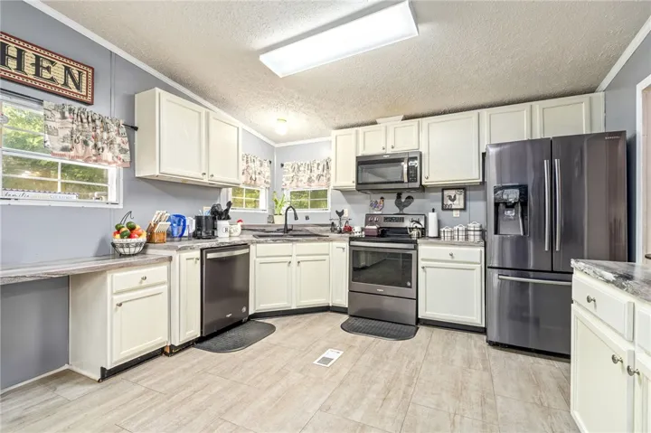 A classic layout connects abundant cabinetry with durable wood-look flooring.