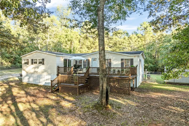 Mature trees frame the multi-level wooden deck of this quiet country residence.