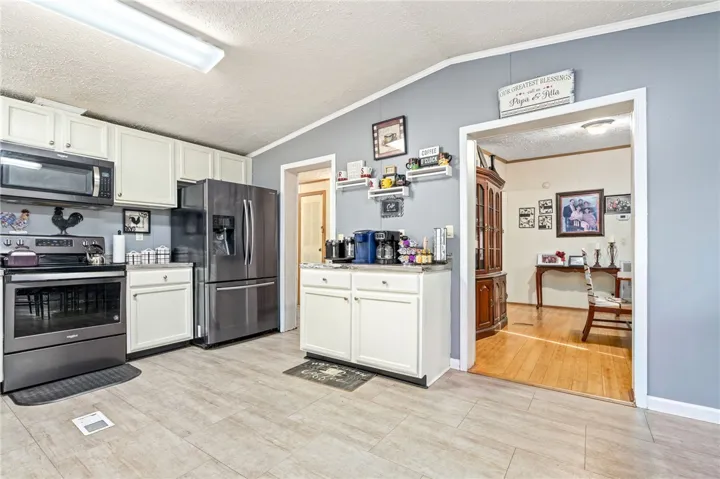 Gleaming tile floors anchor this functional kitchen layout connecting seamlessly to the dining area.