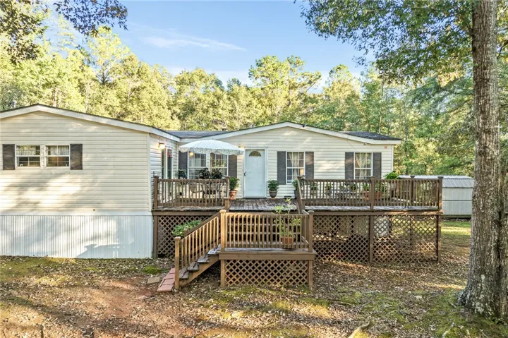 A spacious multi-level wooden deck extends from the front of this vinyl-sided home.