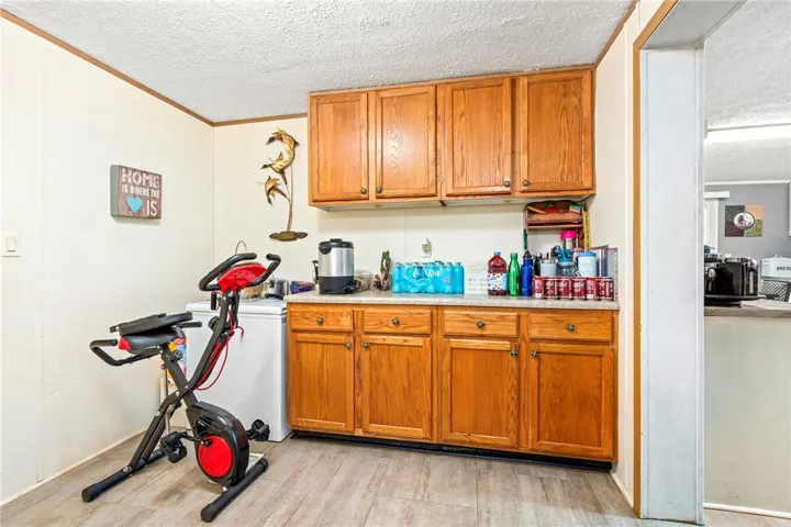 Ample wooden cabinetry and durable vinyl flooring highlight this versatile utility area.