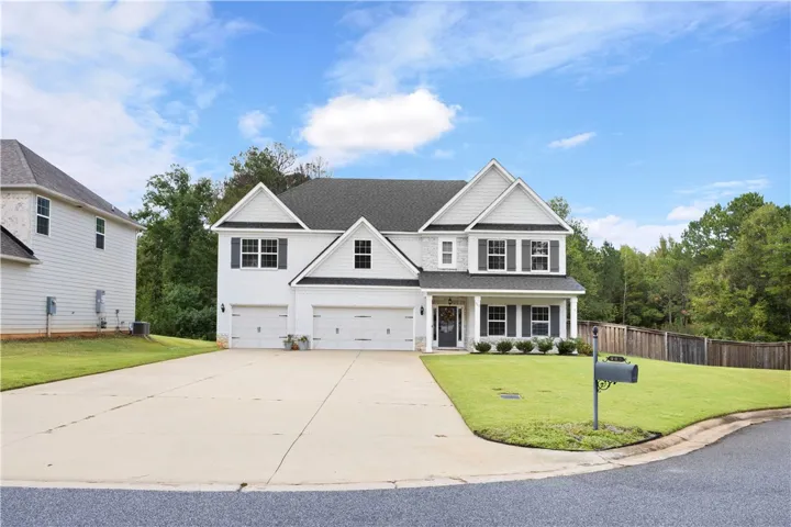 A spacious concrete driveway leads to this classic multi-gabled home with integrated garage parking.