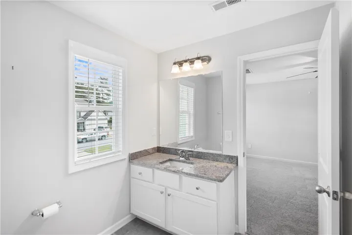 Polished stone counters finish this elegant vanity alcove adjacent to the main bedroom.